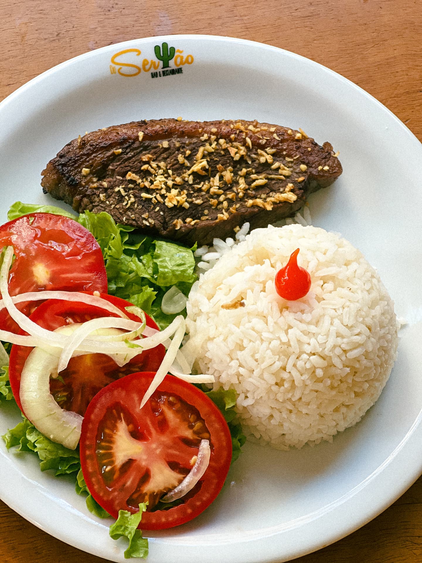 Prato servido no Do Sertão: carne grelhada com alho, arroz e salada fresca